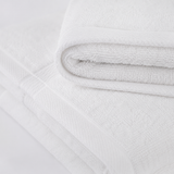 Close-up of a textured white fabric with a subtle pattern on a light gray background