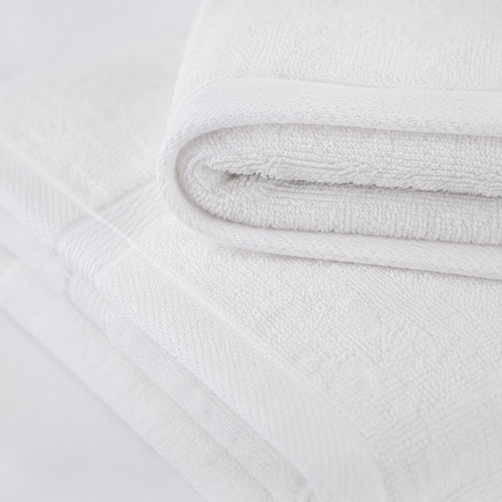 Close-up of a textured white fabric with a subtle pattern on a light gray background