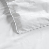 Close-up of a white duvet on a matching white fabric background