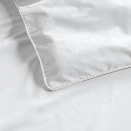 Close-up of a white duvet on a matching white fabric background