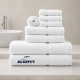 Stack of white towels with Bluefin logo on a bathroom counter