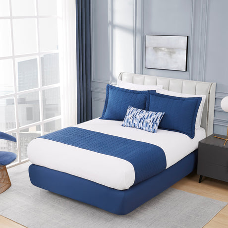 Modern bedroom with a blue and white bed, chair, and side table.