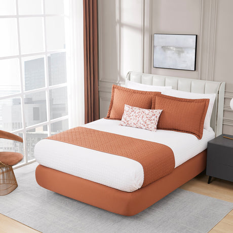 Bedroom with a bed featuring brown and white bedding, a chair, and a lamp.