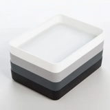 Stack of three rectangular ceramic dishes in black, gray, and white on a white background