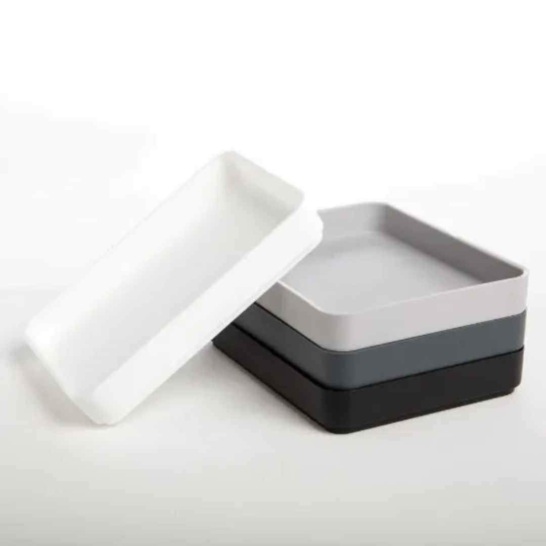 Set of three square trays in white, gray, and black on a white background