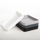 Set of three square trays in white, gray, and black on a white background