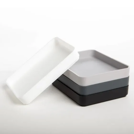 Set of three square trays in white, gray, and black on a white background