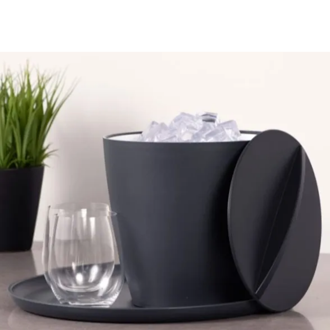 Dark gray ice bucket with lid, glass of water, and ice cubes on a light surface.