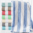 Stack of folded towels with blue and white stripes on a white background