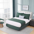 Modern bedroom with a green and white bed, side table, and chair.