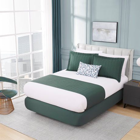 Modern bedroom with a green and white bed, side table, and chair.