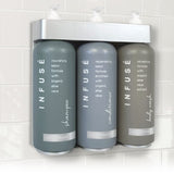 Three gray bottles labeled 'Infuse' on a white tiled wall.