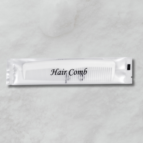 White comb packet labeled 'Hair Comb' on a gray background