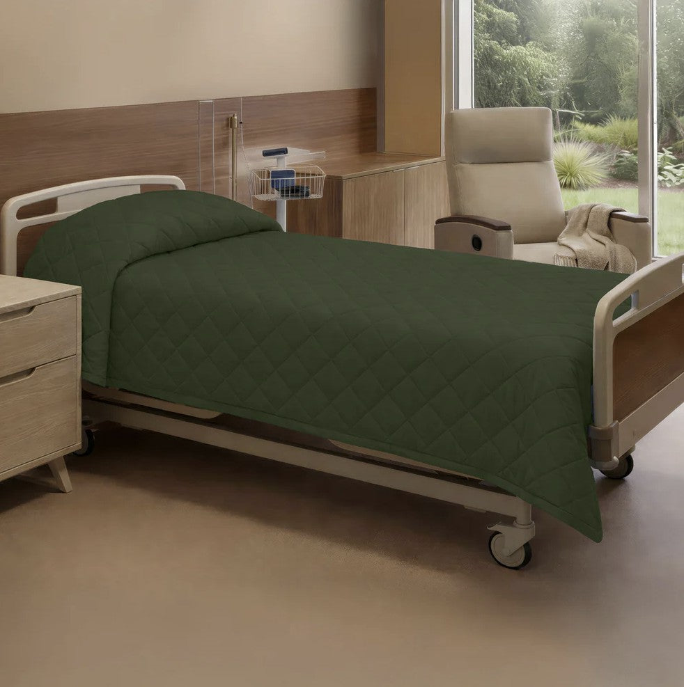 Hospital bed with green bedding in a room with a window view