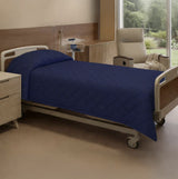 Hospital bed with blue cover in a room with a window and chair.