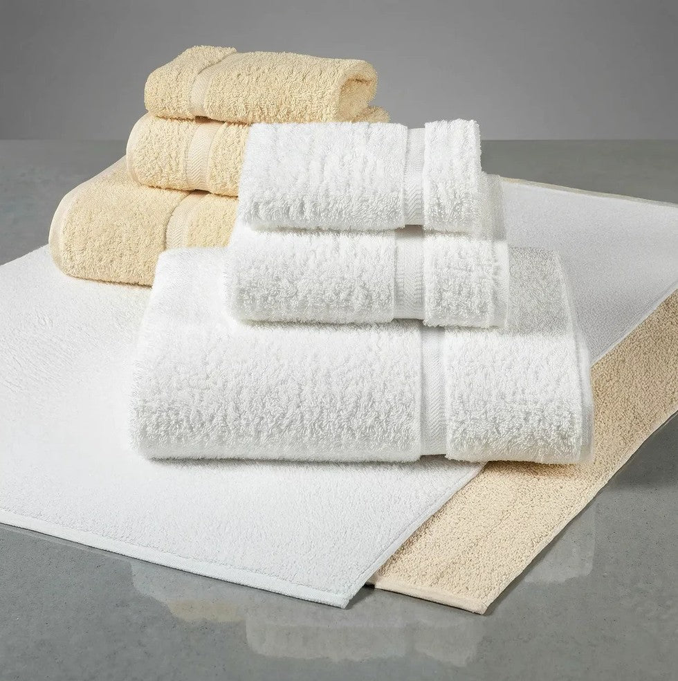 Stack of white and beige towels on a gray surface