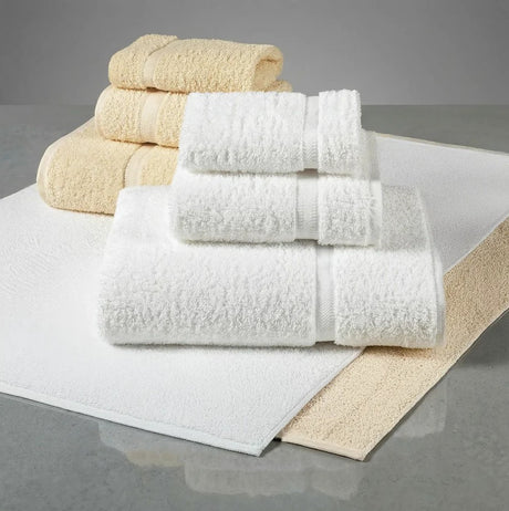 Stack of white and beige towels on a gray surface