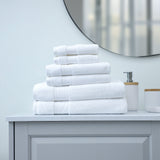 Stack of white towels on a bathroom counter with a mirror in the background