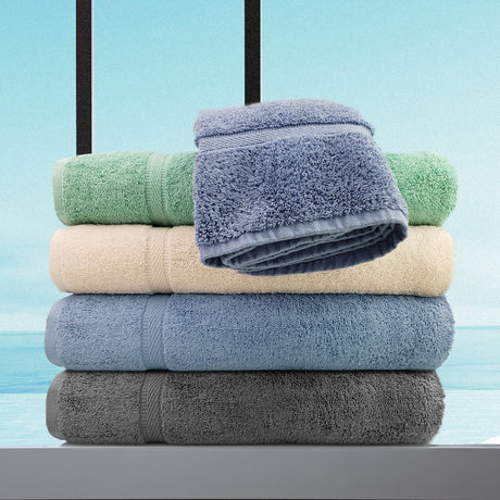 Stack of folded towels in various colors on a light blue background