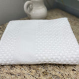 White textured cloth on a granite countertop with a blurred background