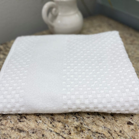 White textured cloth on a granite countertop with a blurred background