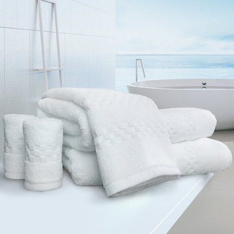 Stack of white towels on a bathroom counter with a bathtub in the background