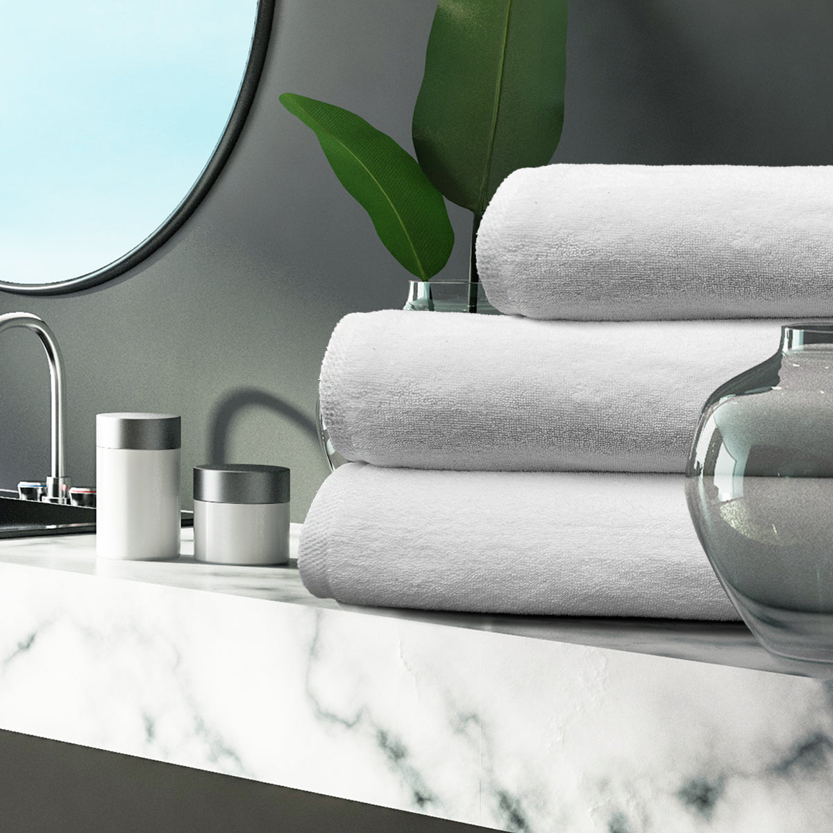Stack of gray towels on a marble countertop with decorative items.