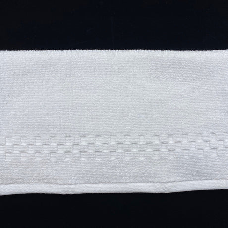 Close-up of a white fabric strip with a black background