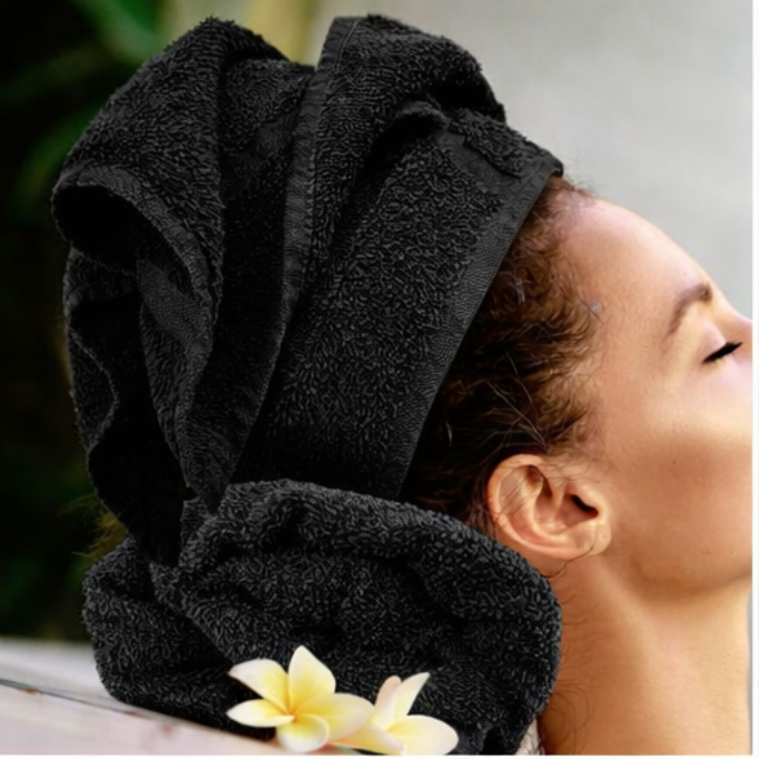 Person with a black towel wrapped around their head, with a blurred background