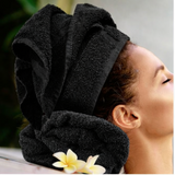 Person with a black towel wrapped around their head, with a blurred background