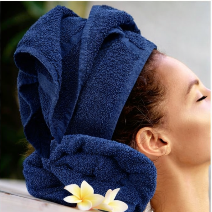 Person wearing a blue towel on their head with a flower in the foreground