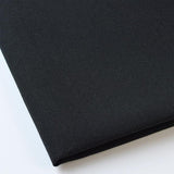 Pictured: Close up of the Premier Napkin neatly folded in the shade Black against a white background.