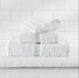 Stack of white towels on a white tiled wall background