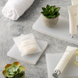 Bathroom setting with toiletries, soaps, and plants on a gray surface