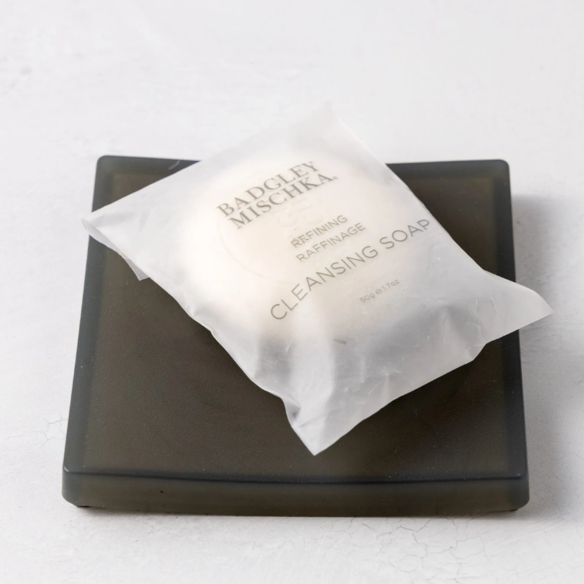 Bar of soap on a black soap dish with a white background