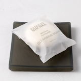 Bar of soap on a black soap dish with a white background