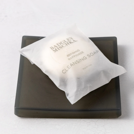 Bar of soap on a black soap dish with a white background