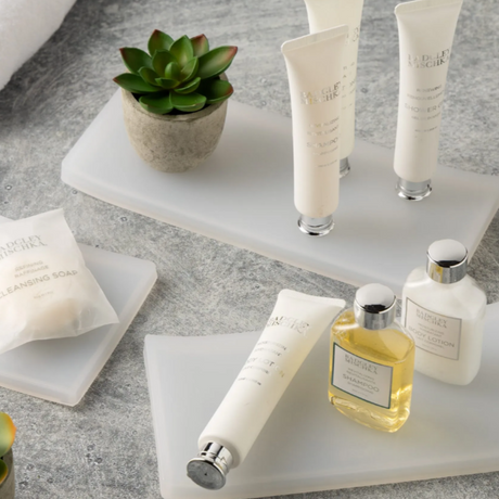 variety of amenity trays with soaps and lotion on top.