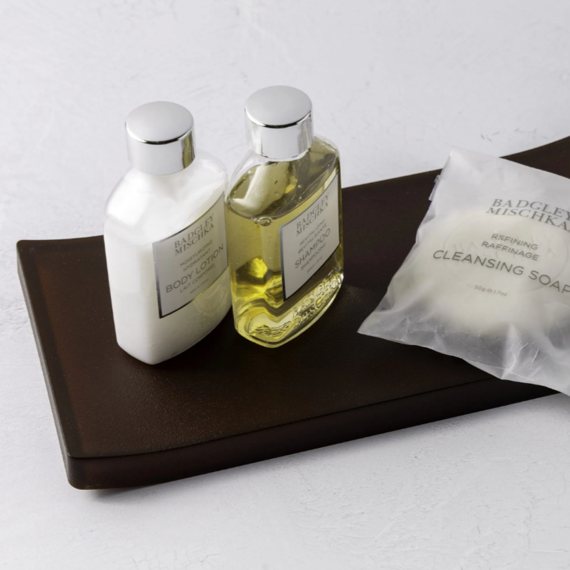 amenity tray in brown with soap and lotions on top.