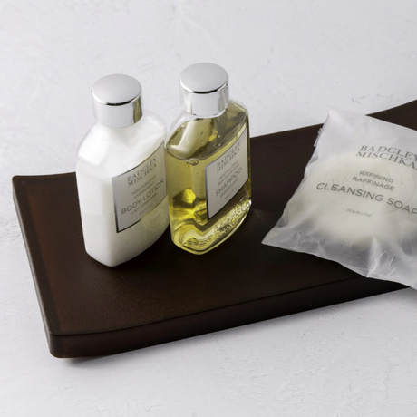 amenity tray in brown with soap and lotions on top.