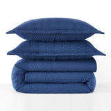 Stack of blue quilted bedding on a white background