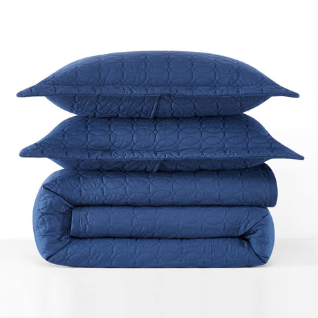Stack of blue quilted bedding on a white background