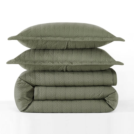Stack of green quilted bedding on a white background