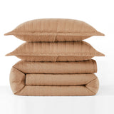 Stack of beige quilted bedding on a white background