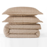 Stack of beige quilted bedding on a white background