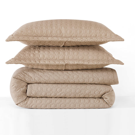 Stack of beige quilted bedding on a white background