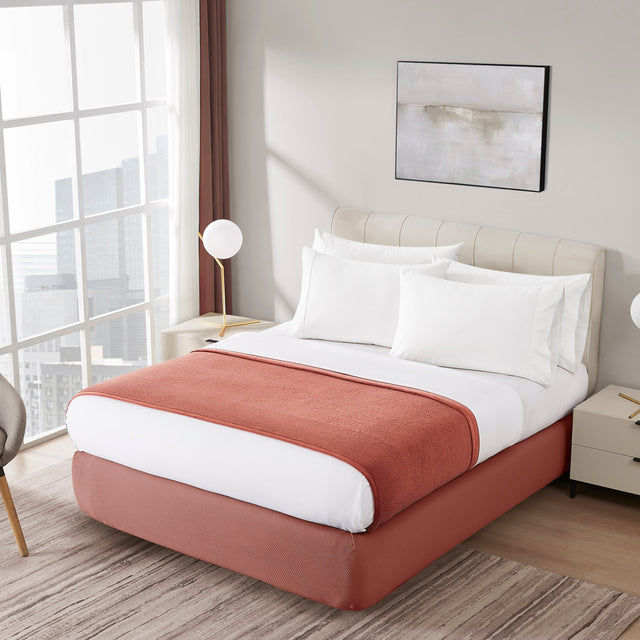 Modern bedroom with a bed, chair, and decor elements.