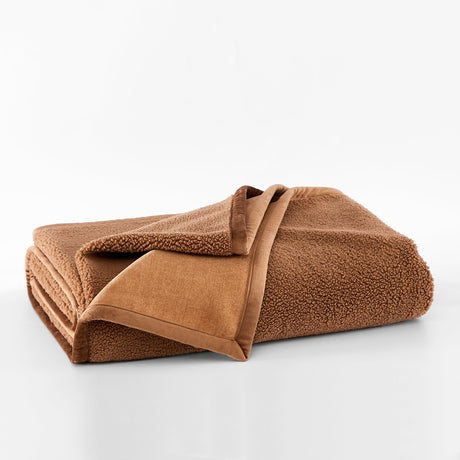 Folded brown blanket on a white background