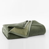 Folded green towel on a white background
