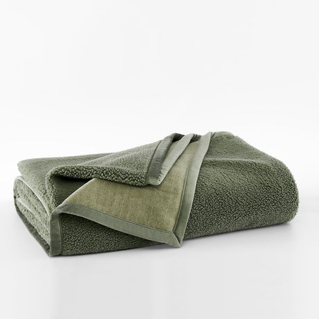 Folded green towel on a white background